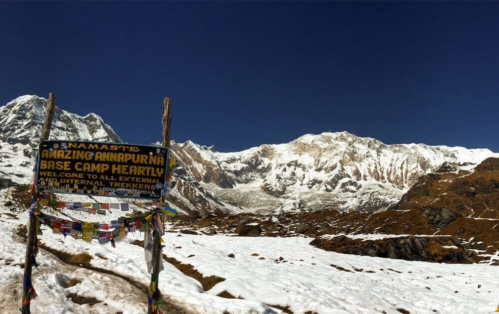 beautiful annapurna mountain views with blue sky and welcome board at annapurna base camp in annapurna base camp trek.