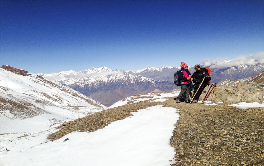 trekkers are descending after throng la pass on annapurna circuit trek and magnificent view of the mountains with blue sky on a clear day.