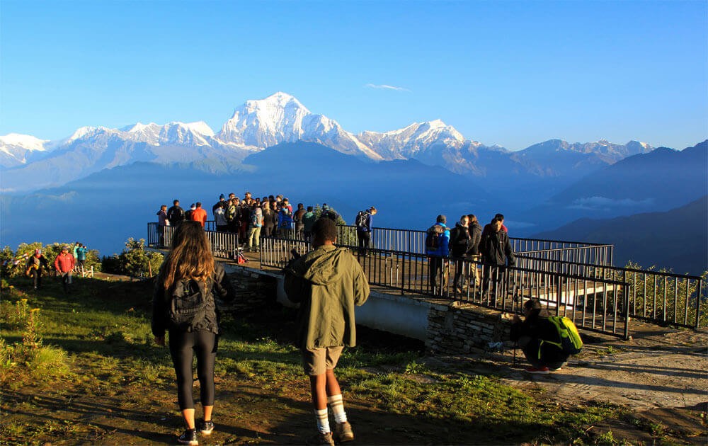 trekkers at pon hill and beautiful view of the mountains with blue sky on annapurna view trek.