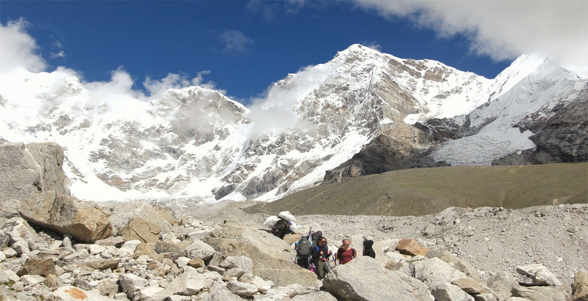 trekkers heading on to the everest base cap in march, clear weather with a few cloudes, blue sky and mountains.