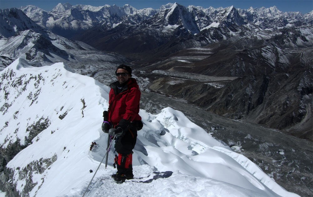 a climber at summit of island peak and mountain views from the the summit on island peak climbing.