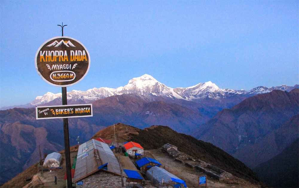 trekkers at khopra danda and magnificent view of dhaulagiri mountains with blue sky on a clear day in khopra danda trek.