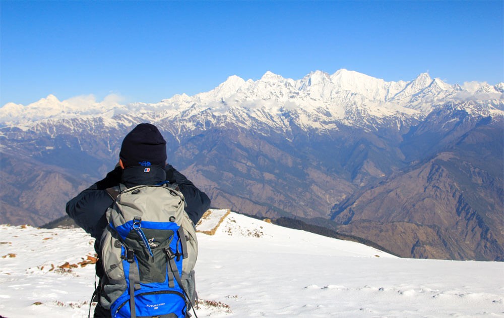 a trekker at lauribinayak hill, magnificent view of mt.manaslu, ganesh himal and langtang himalayas with blue sky on langtang gosaikunda trek.