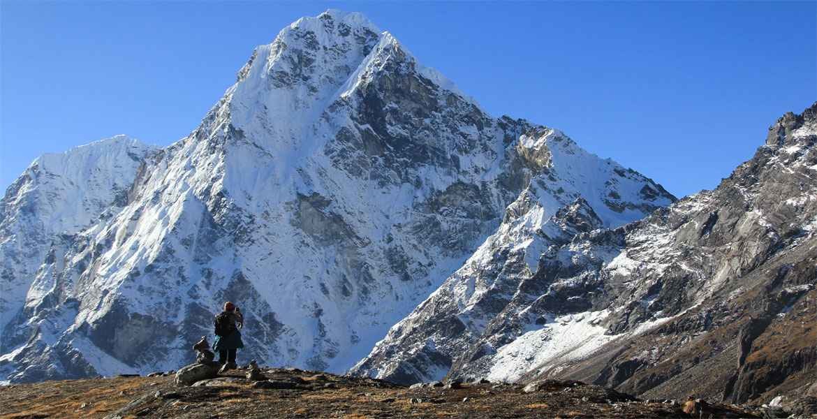 a single female traveller taking photo in cho la pass trekking trail while travelling with a guide from frolic adventure.