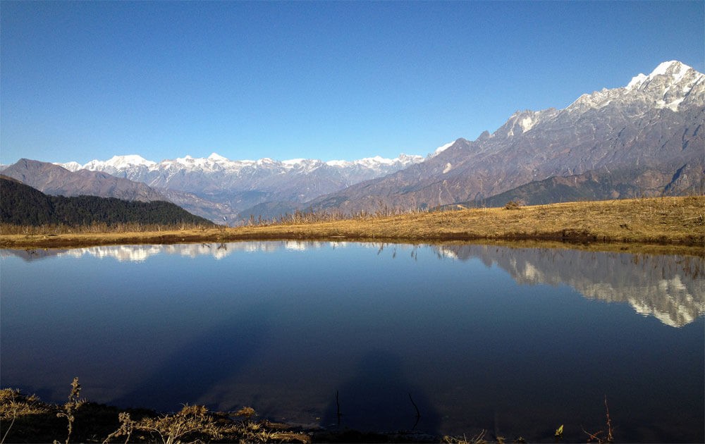 beautiful mountain views reflecting in a pong at nagthali hill on tamang heritage trek.