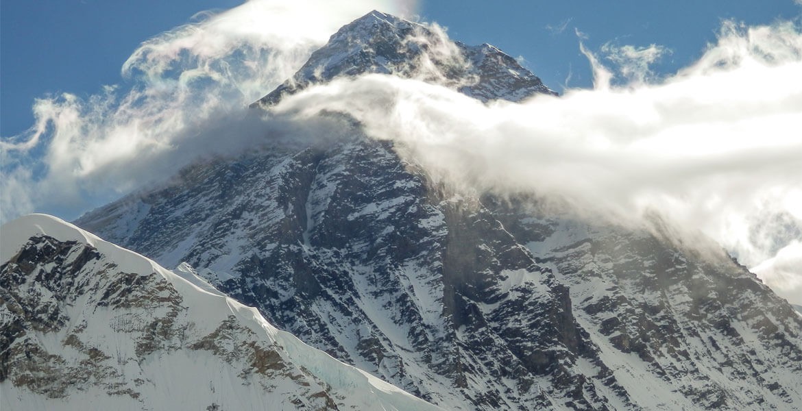 mount everest is located very close to a vantage viewpoint kala patthar, blue sky with a few clouds in the afternoon during everest base camp trek.