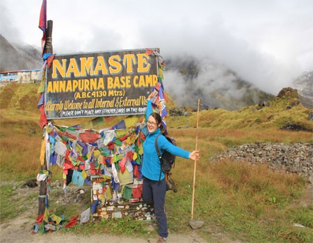 a trekker celebrating successful abc trek by taking picture with the sign.